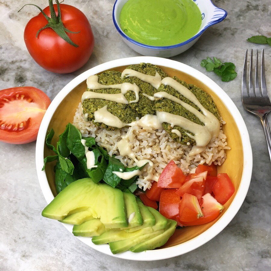 Green baked falafels over brown basmati rice, tomatoes, spinach, and avocado. I drizzled some tahini on top and cilantro tahini on the side. 