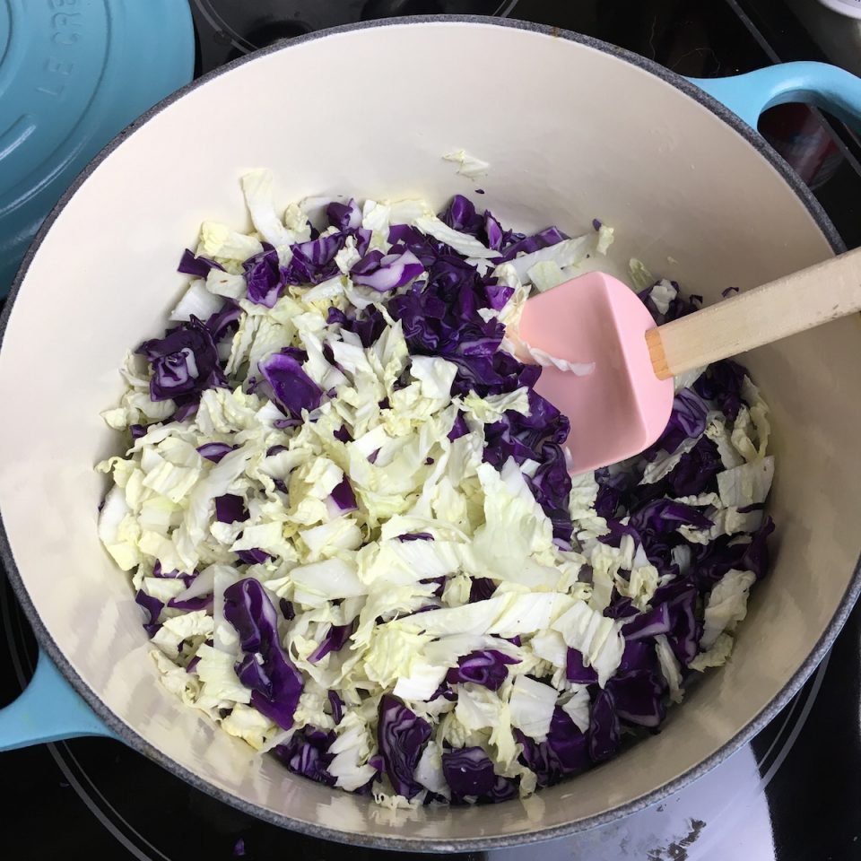 Stirring the napa and purple cabbage in with all the other ingredients.