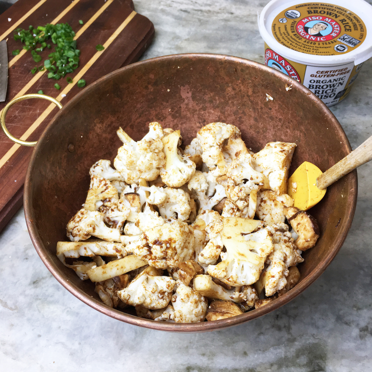 Mixing the miso sauce on the cauliflower and mushrooms. 